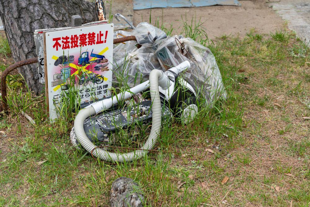 不法投棄禁止と書かれた看板の横に捨てられた掃除機